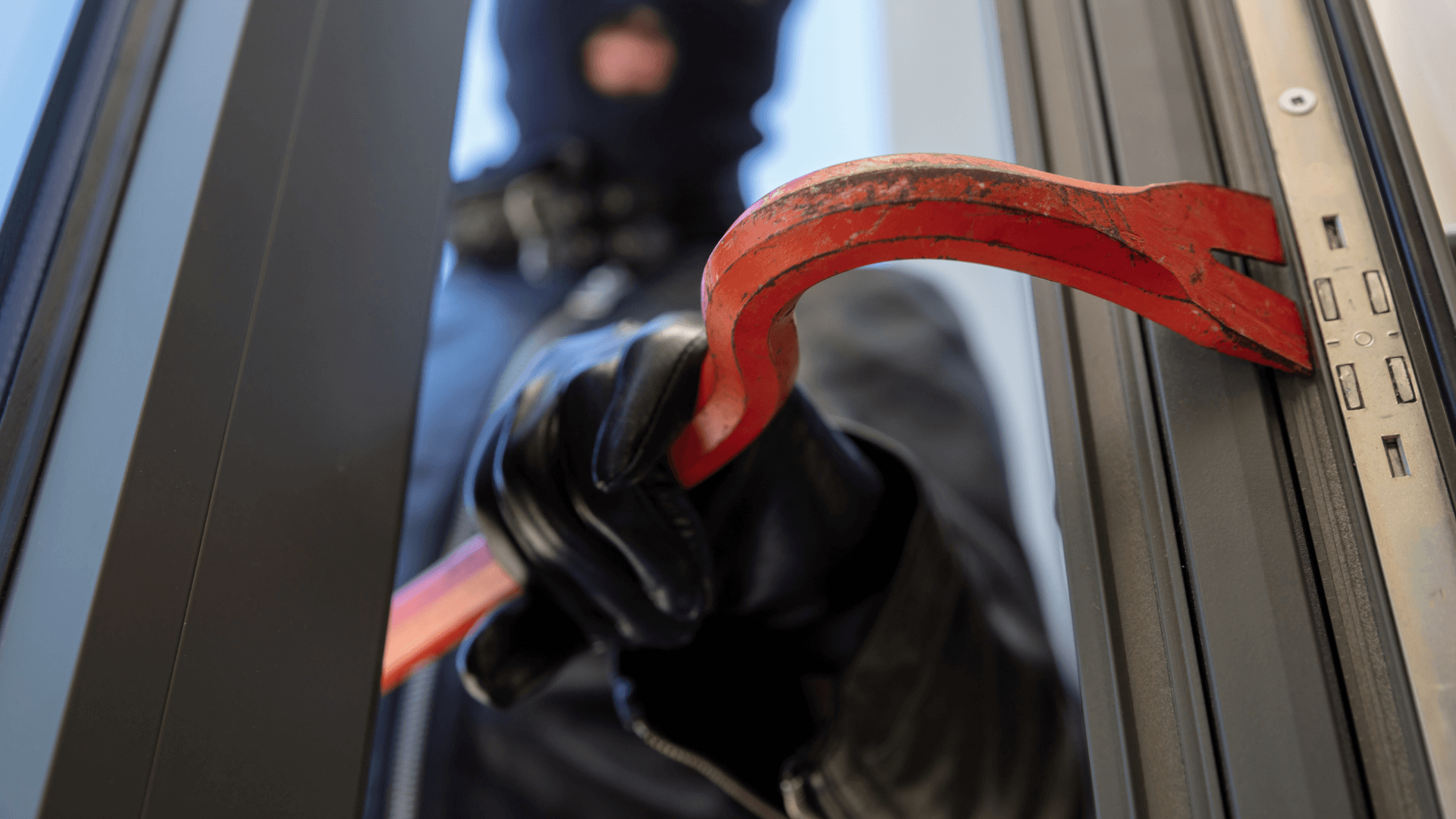 Burglar using crowbar to break in