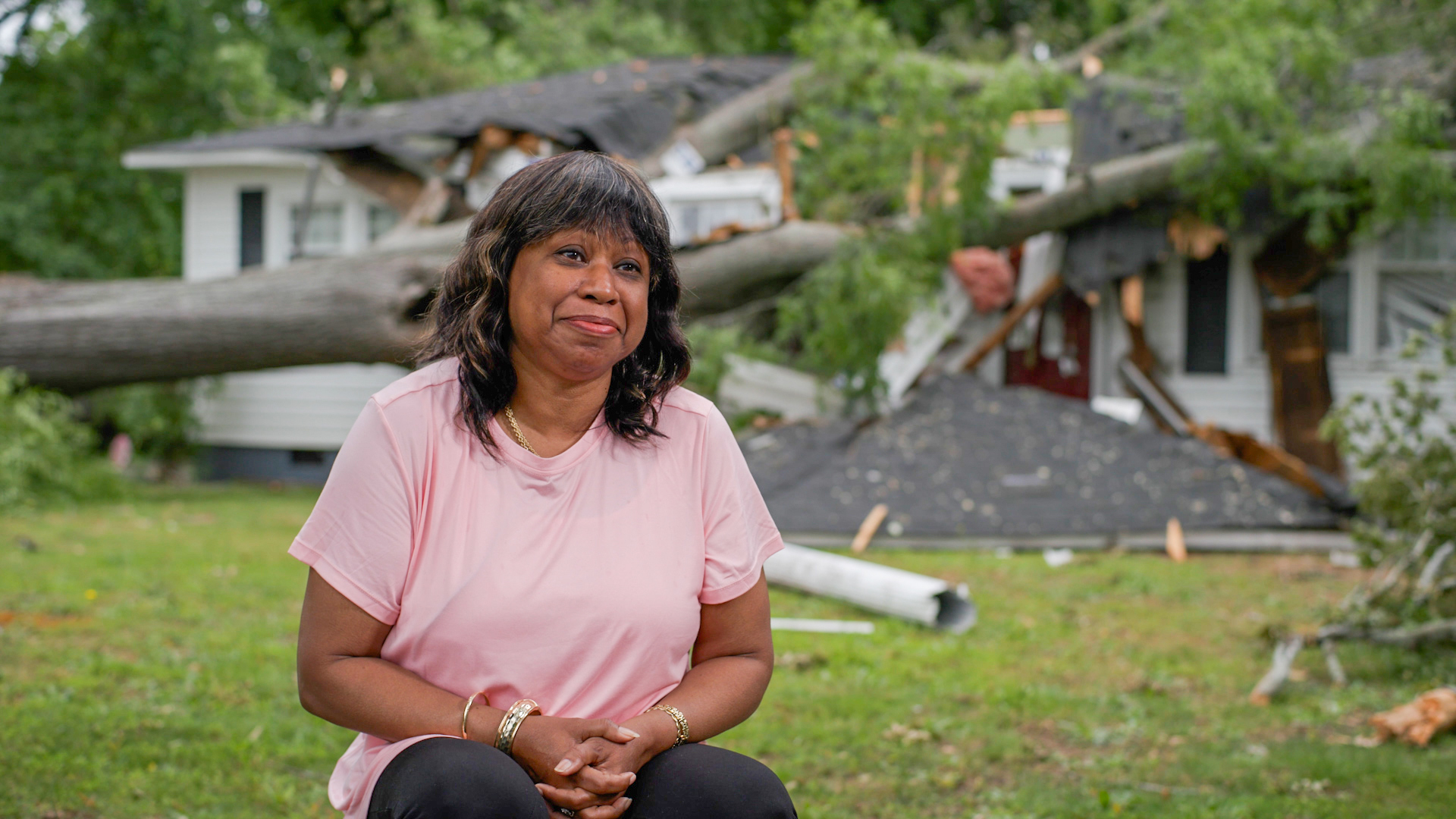 Devery Davis in front of crushed home