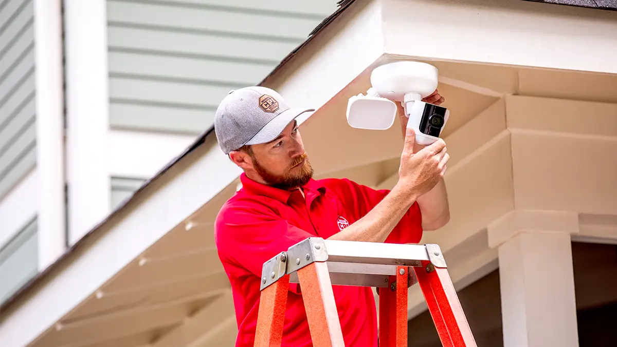 CPI technician installing an outdoor floodlight camera